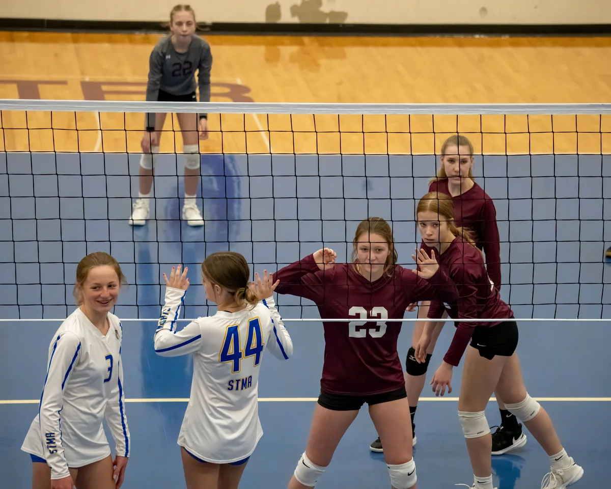 Youth volleyball players during an indoor match